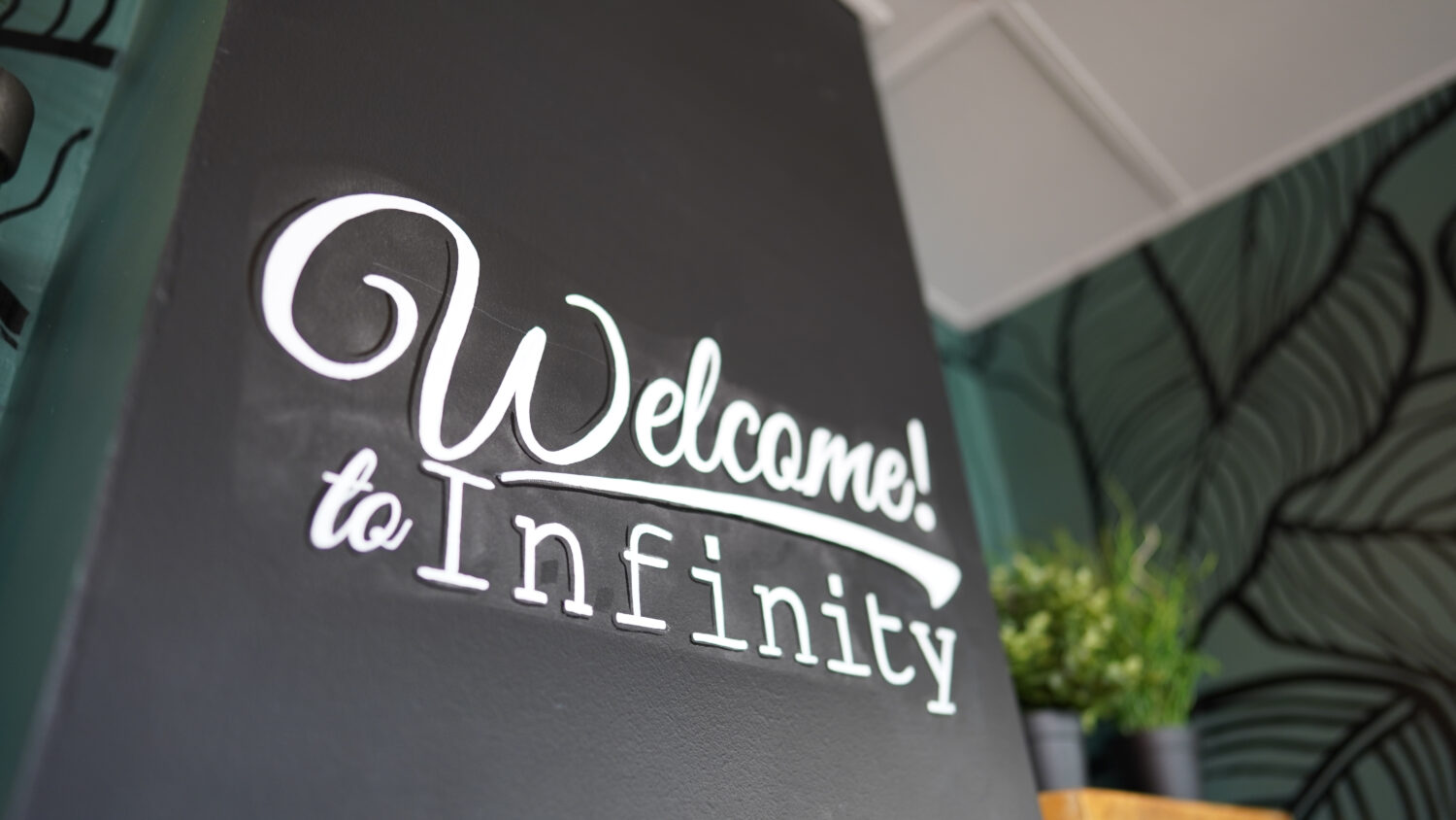 Close-up photo of a sign inside the Infinity Cafe at Leigh Academy Snowfields. The sign reads 'Welcome to Infinity'.
