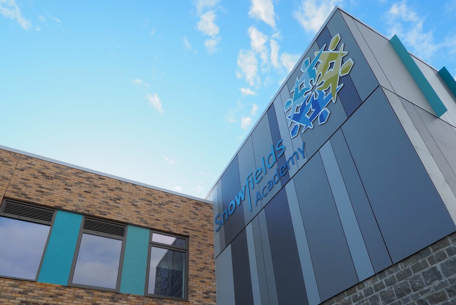 Close-up exterior shot of the academy logo sign on the Leigh Academy Snowfields building.