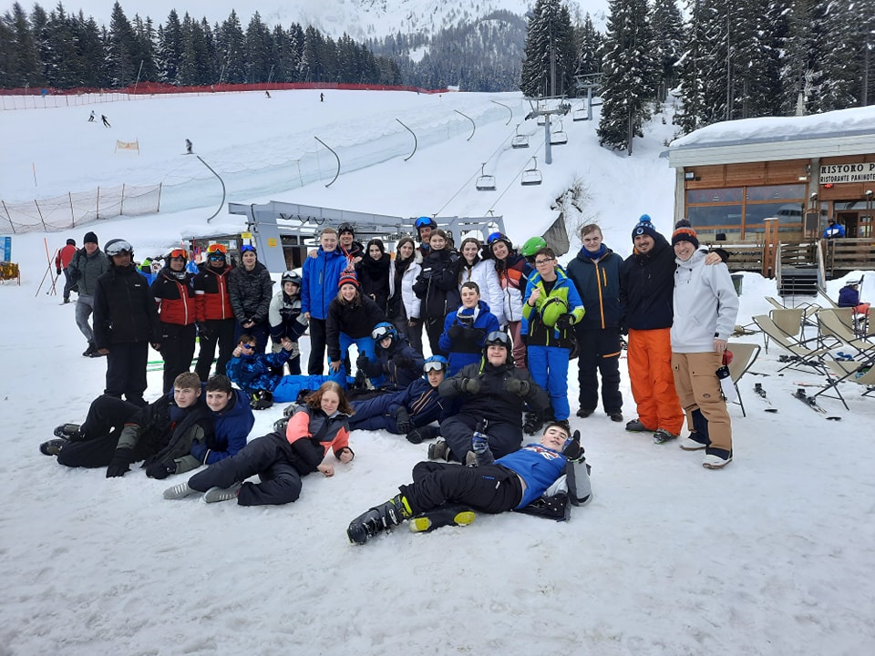 A large group of students from Leigh Academy Snowfields are pictured smiling together in a snowy location, alongside their teachers, during a Skiing Trip abroad.