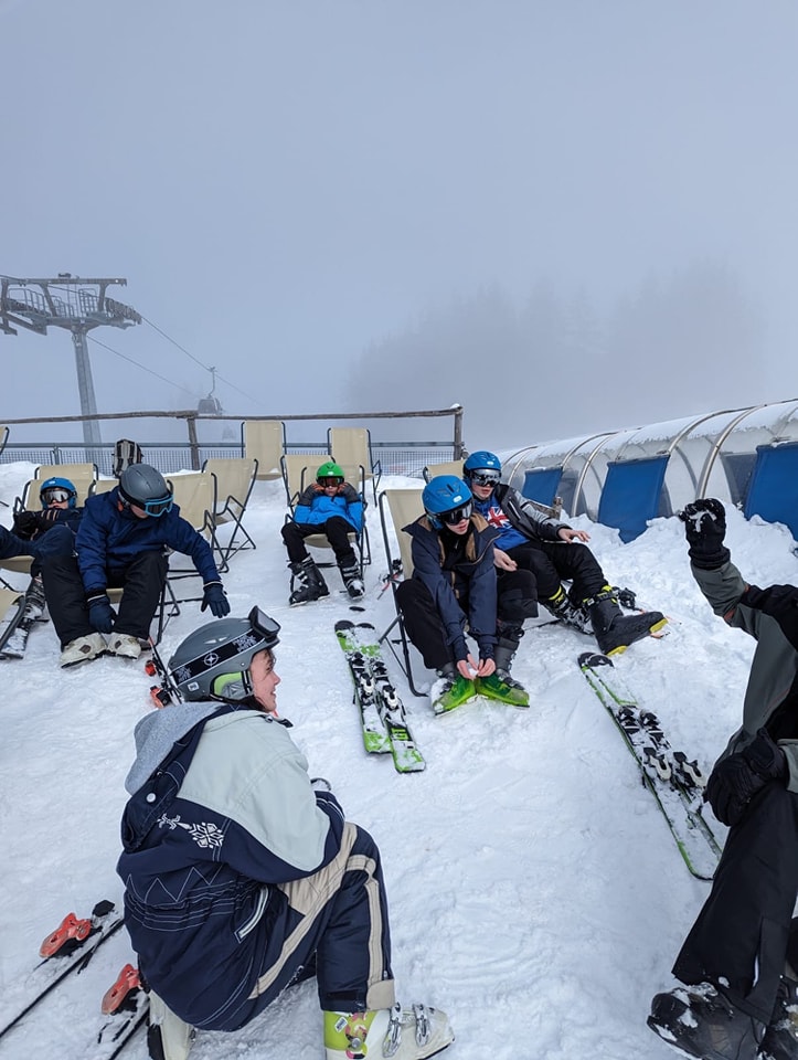 A group of students from Leigh Academy Snowfields are pictured preparing to ski down a snowy hillside during a school trip abroad.