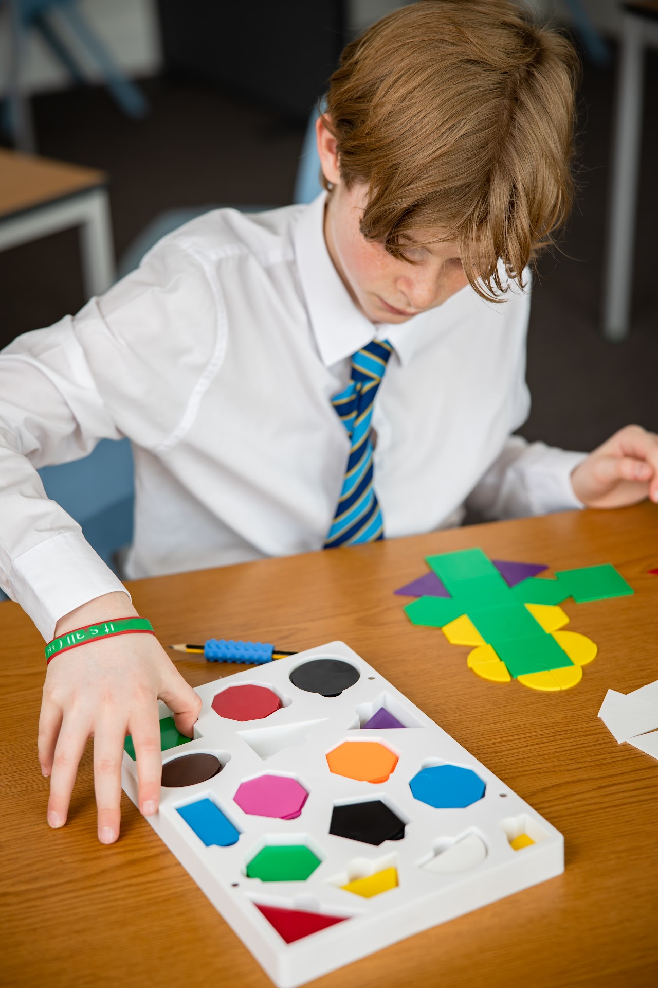 A student at a desk looking at colourful shapes