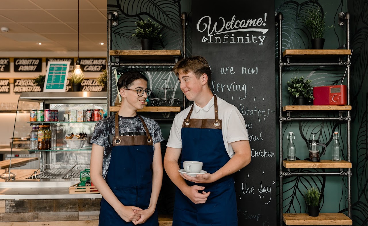 2 students holding coffee cups in a canteen