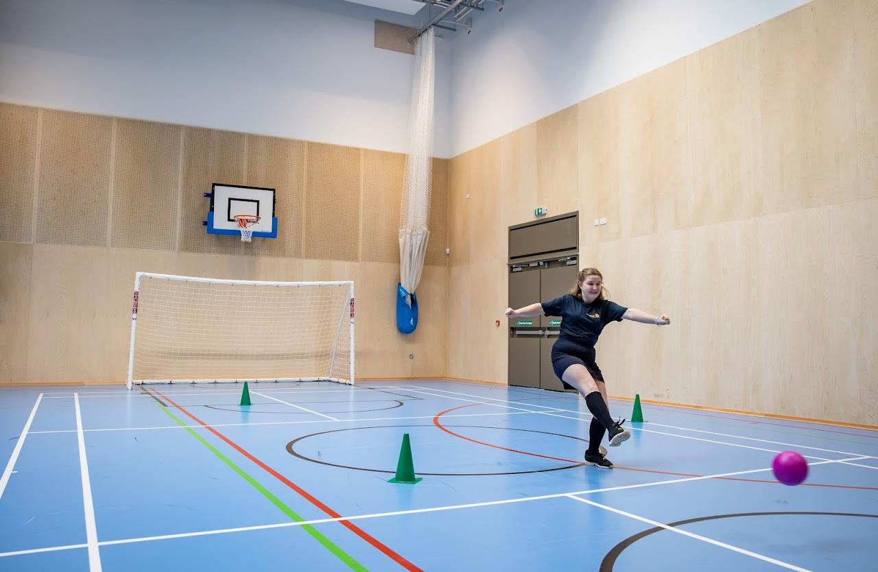 A student in a PE kit in a gym